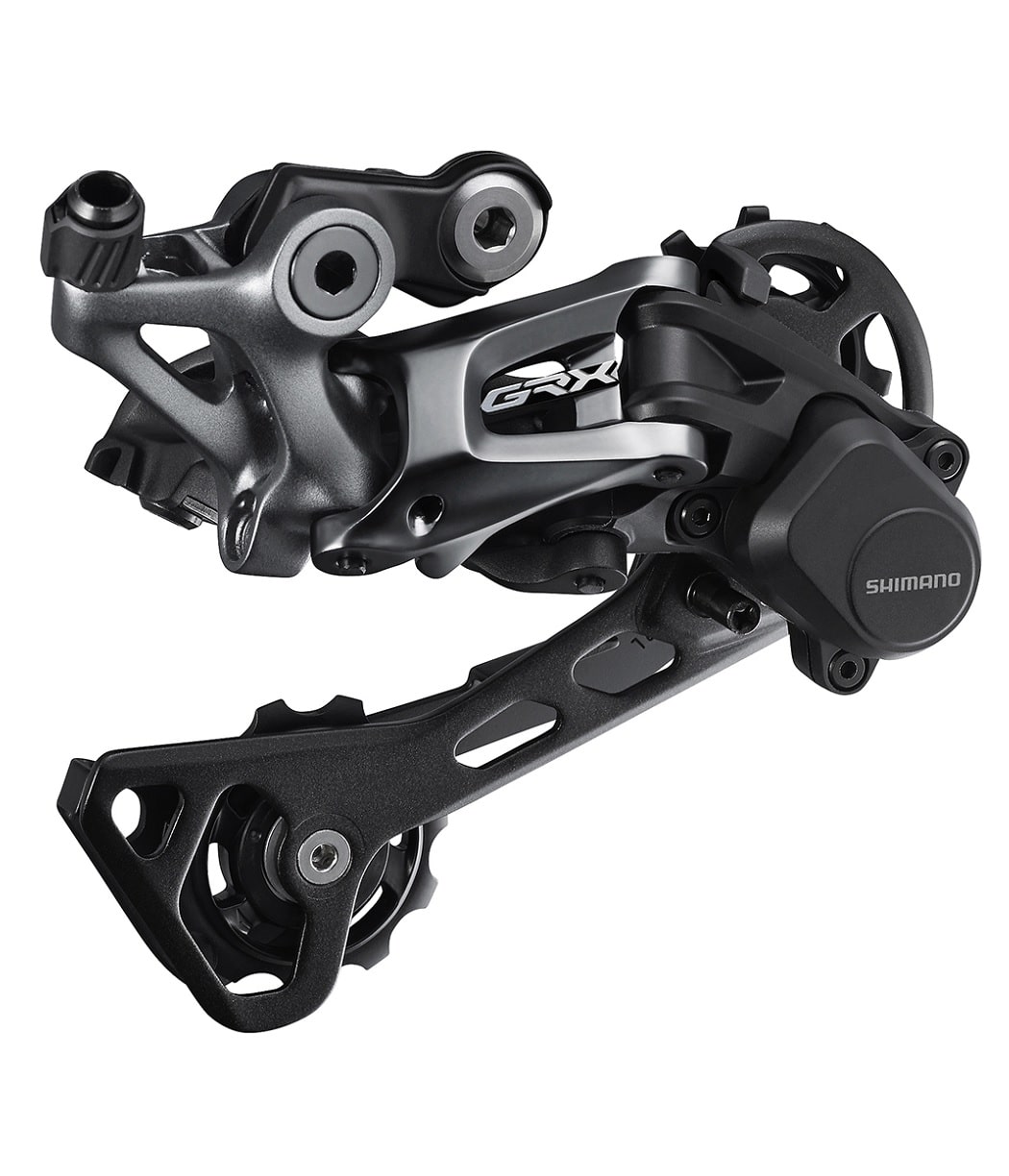 Bakvaxel-11-vxl-GRX-RD-RX812.jpg En detaljerad närbild av en Shimano GRX RD-RX812 1x11s bakväxel. Belysningen framhäver de metalliska och svarta komponenterna, vilket ger ett tekniskt och högkvalitativt intryck.