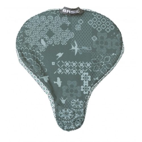 Basil Boheme sadelskydd i dämpad grå nyans med ett mönster av stiliserade fåglar, blommor och geometriska former. Bra belysning framhäver textilen och de fina detaljerna.