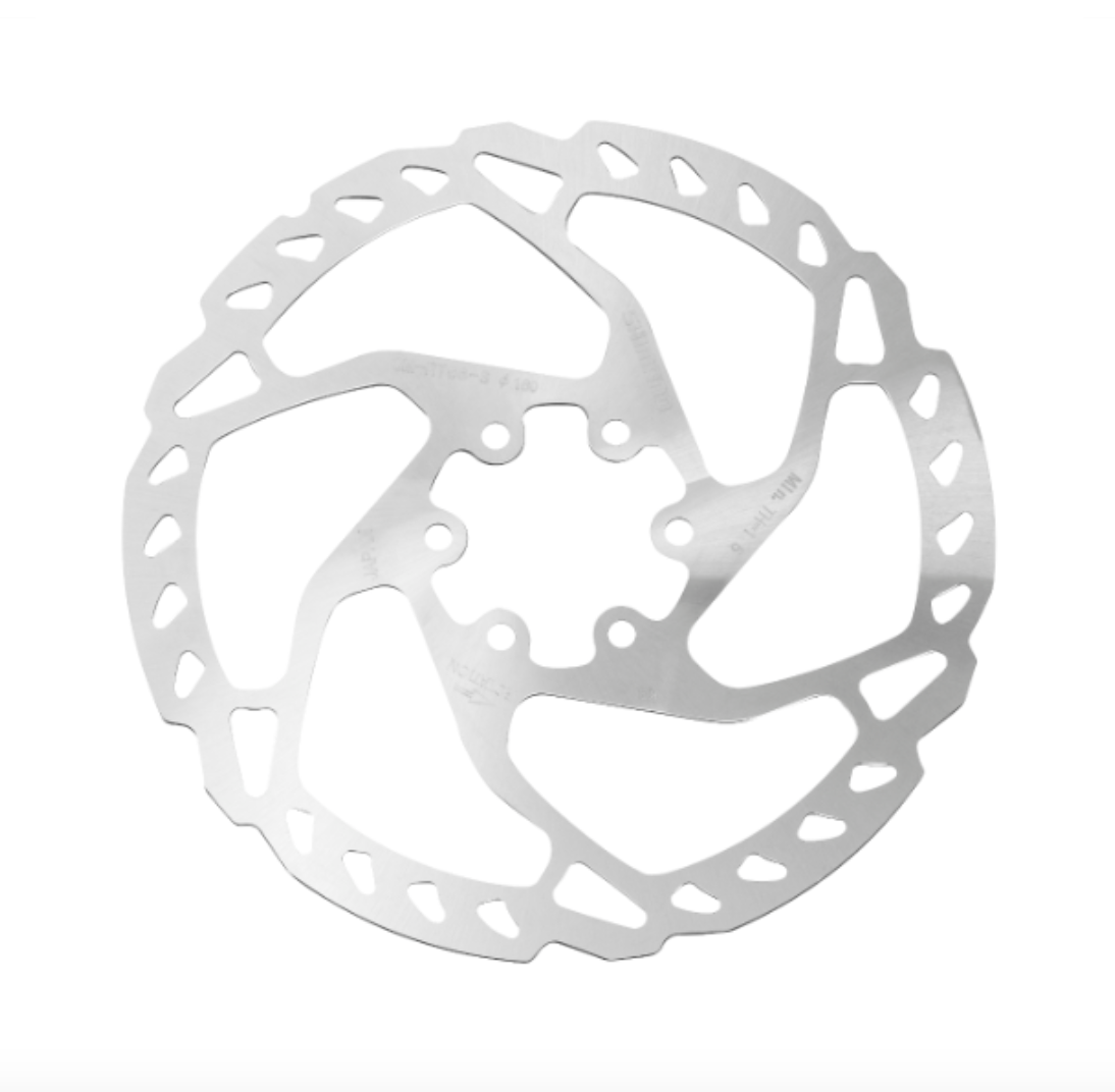 Bromsskiva Shimano SM-RT66 Detaljerad bild av en Shimano Deore/SLX SM-RT66 bromsskiva för 6-bults montering. Silverfärgad metall med karakteristiska utskärningar, fotograferad i mjukt ljus mot en vit bakgrund.