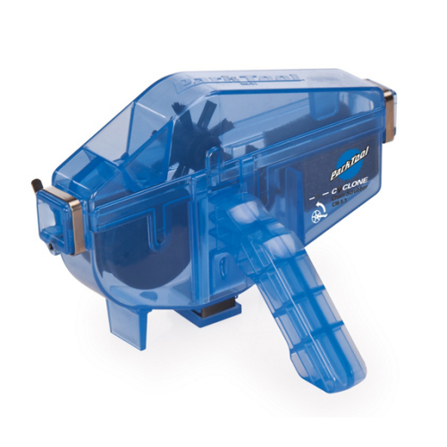 En blå Park Tool CM-5.3 kedjetvätt syns mot en vit bakgrund. Den genomskinliga designen visar borstar och mekanismer inuti, vilket framhäver verktygets detaljer och funktion.