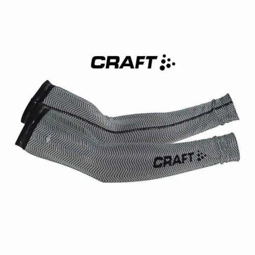 Ett par Craft Shield Arm Warmer-ärmar i svartvitt sicksackmönster med "CRAFT"-logotypen mot vit bakgrund och med varumärket ovanför.