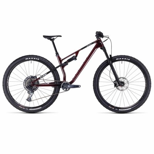 En heldämpad mountainbike med mörkbrun ram, svart framgaffel, skivbromsar, platt styre och Maxxis-däck, sedd från sidan mot en vit bakgrund.