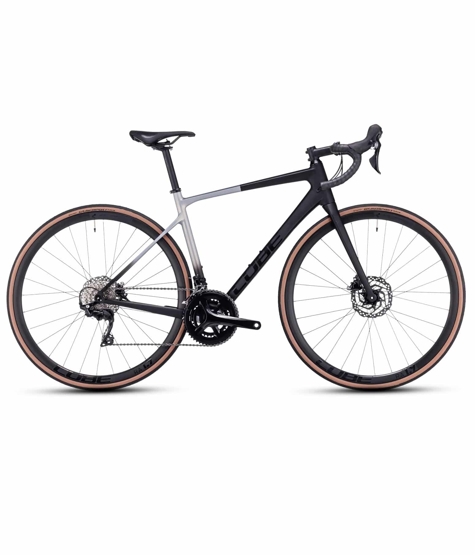 Cube-AXIAL-WS-GTC-23.jpg En modern landsvägscykel med droppstyre, skivbromsar och en lättviktsram. Ramen är svart och silverfärgad och däcken har bruna sidoväggar. Cykeln är fotograferad från sidan mot en vit bakgrund.