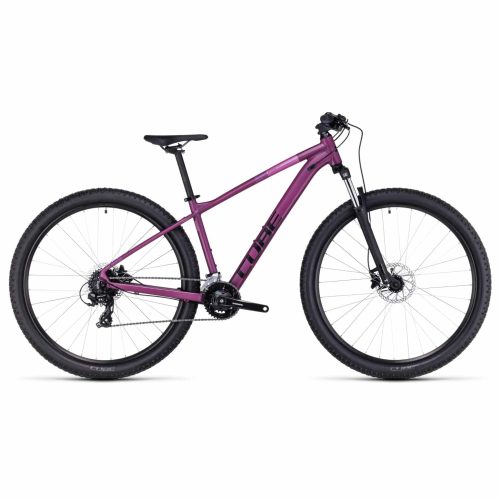 En lila Cube mountainbike med framgaffel med fjädring, svart sadel, platt styre och stora knobbiga däck, visad i profil mot en vit bakgrund.
