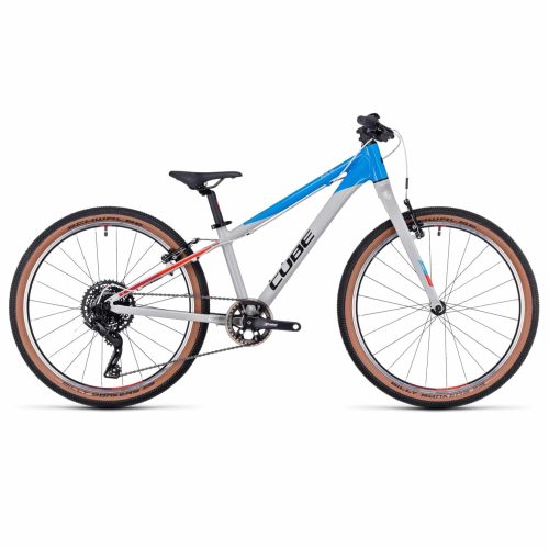 En vit och blå Cube mountainbike med svart sadel, rakt styre och brunfärgade däck visas från sidan mot en vit bakgrund.