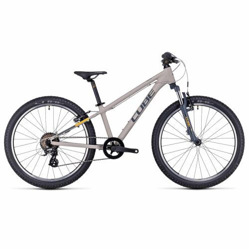 En beige Cube mountainbike med svart sadel, rakt styre, framgaffel med fjädring och tjocka däck, visad i profil mot en vit bakgrund.