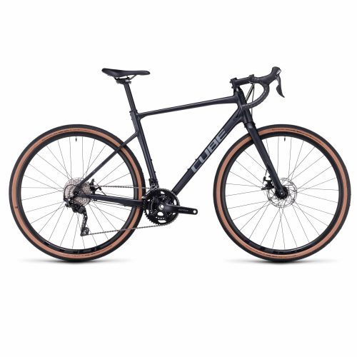 En svart CUBE gravelcykel med droppstyre, skivbromsar och däck med solbrända sidor, visad i profil mot en vit bakgrund.