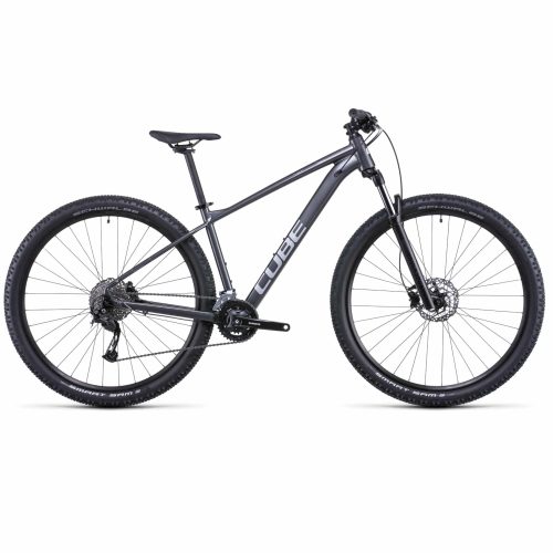 En grå MTB 27,5" Cube Aim SL med framfjädring, platt styre, skivbromsar, stora knobbydäck och "CUBE" tryckt i vitt på ramen, sedd från sidan.