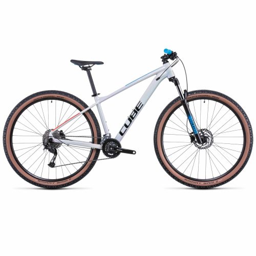 En sidoprofilvy av MTB 27,5" Cube Aim SL 27,5" - Vit mountainbike i silver och svart med tan-däck, framfjädring, skivbromsar och "CUBE"-märke på ramen mot en vit bakgrund.