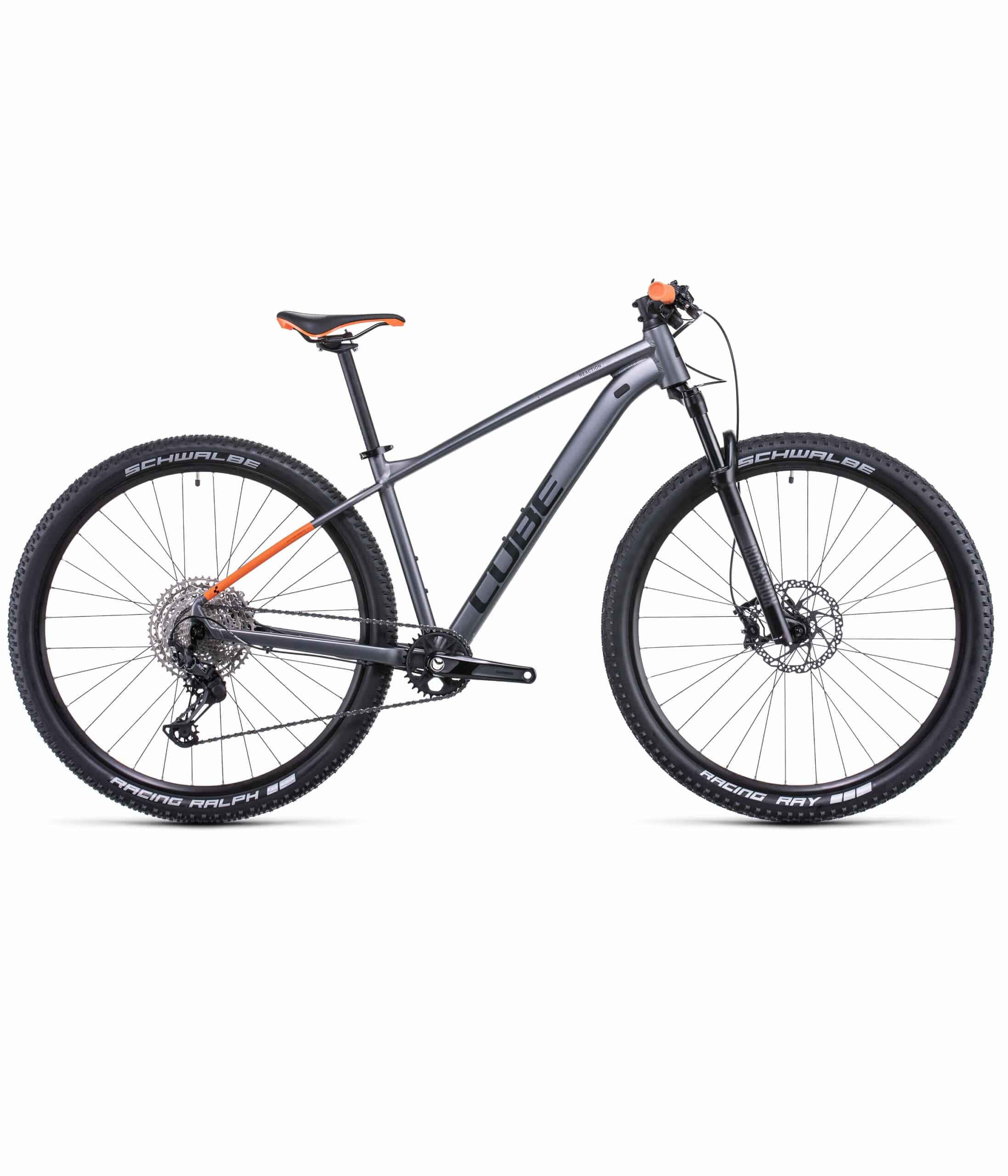 Cube-reaction-pro-go-22-scaled-1.jpg En grå Cube mountainbike med svarta och orangefärgade detaljer, med framfjädring, skivbromsar och Schwalbe Racing Ralph-däck, visad i sidoprofil mot en vit bakgrund.