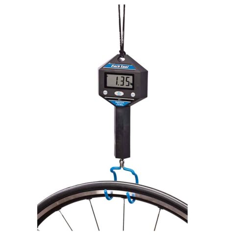 ParkTool DS-1 digitalvåg hänger med en blå krok och väger ett cykelhjul. Displayen visar 1.35. Ljuset är jämnt fördelat och visar detaljer tydligt.
