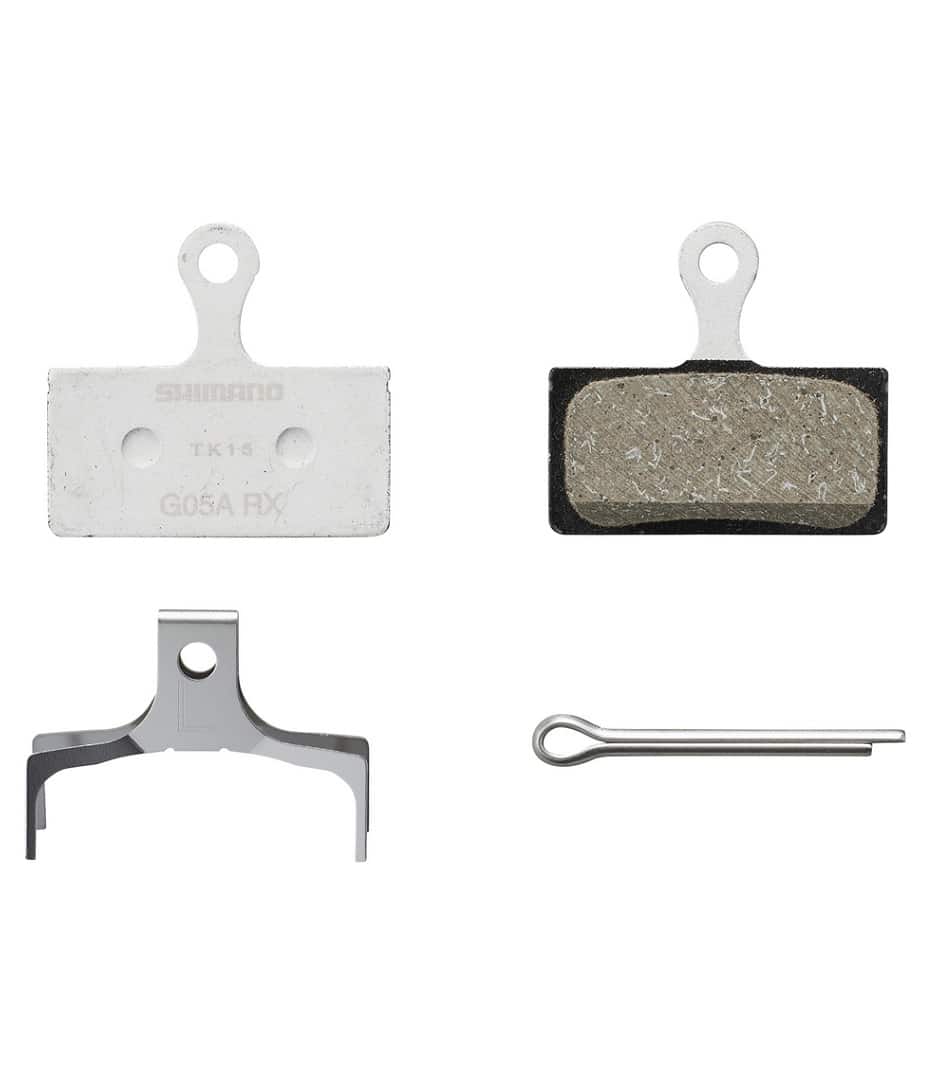 GO3S-Resin.jpg Närbild av Shimano G05A resin skivbromsbelägg. Beläggen, fjädern och sprinten visas mot en ren, vit bakgrund med en lätt skugga som förstärker detaljerna.