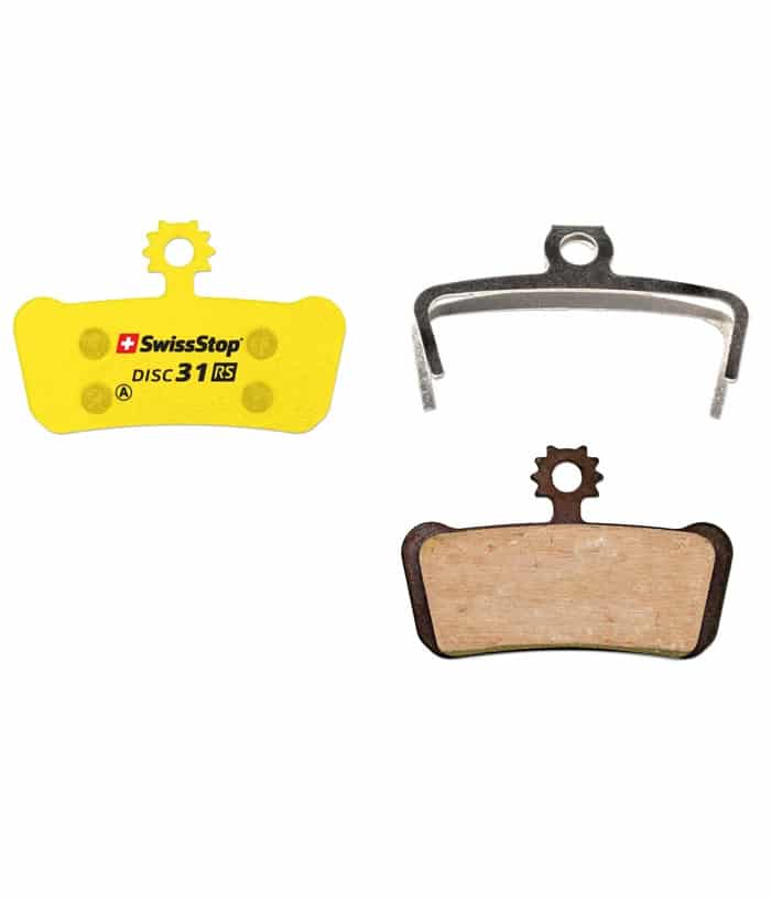 Gul-Disc-31-SS.jpg Närbild av Swissstop Disc 31 organiska skivbromsbelägg, inklusive en gul belägg, en fjäder och en belägg med träfärgad friktionsyta mot en ljus bakgrund.