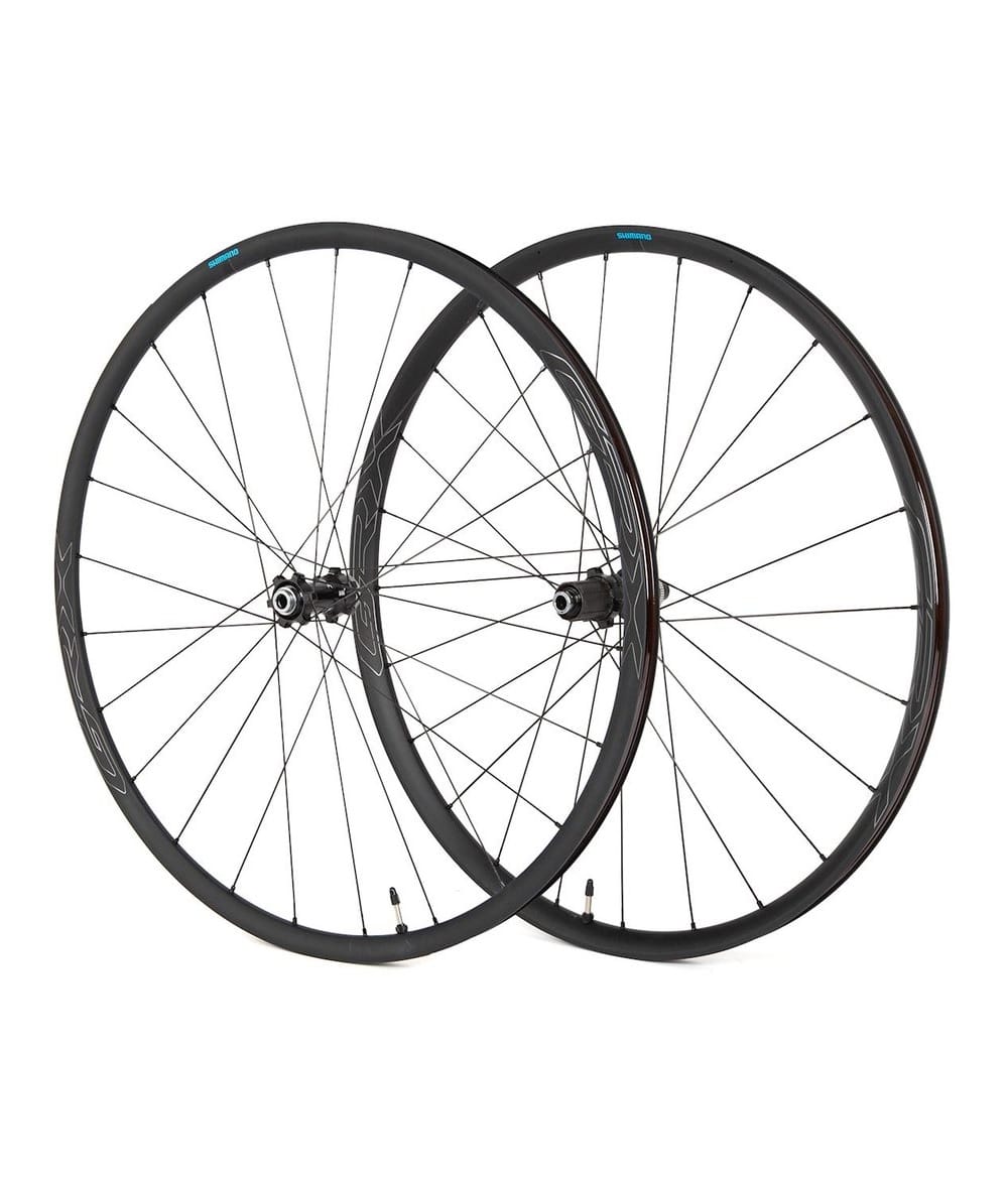 Hjulpar-shimano-RX570.jpg Två Shimano WH-RX570-TL Disc hjul, ett fram och ett bak, presenterade i en studio. Hjulens svarta fälgar och detaljer fångas i ett jämnt, diffust ljus som framhäver deras design.