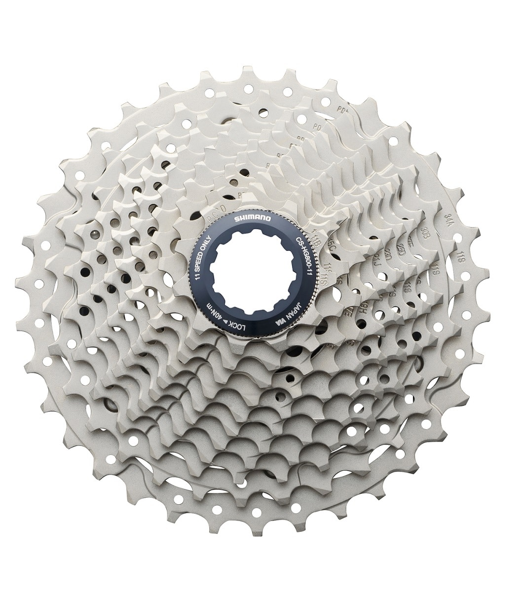 Kassett-Shimano-HG800-11-34.jpg Närbild av en Shimano Ultegra CS-HG800 kassett med 11 växlar. Kassetten är silverfärgad och har en mörkblå låsring i mitten. Belysningen är jämn och detaljerna är skarpa.