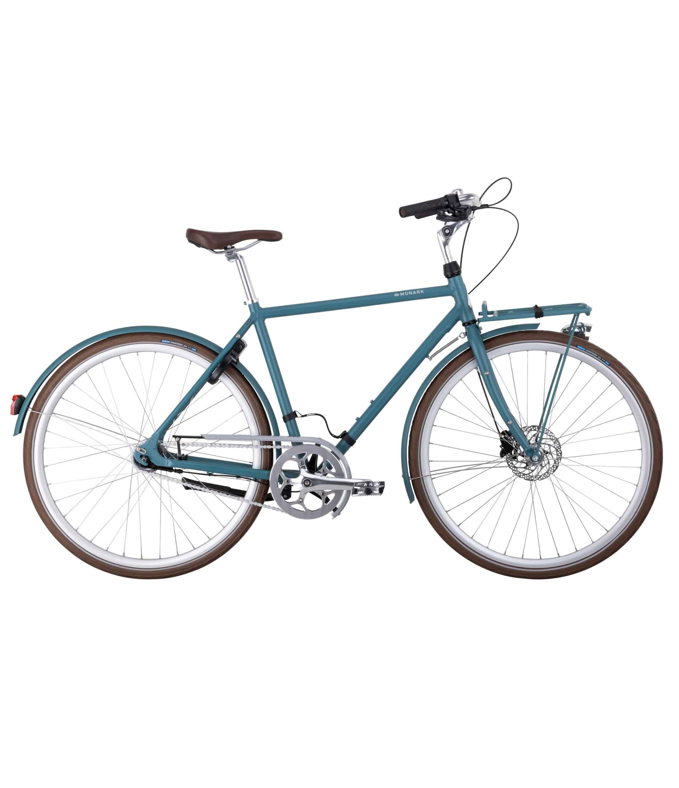 Monark-Sture-7vxl-Bla-scaled-1.jpg En blågrön stadscykel med brun sadel och bruna handtag på styret, fram- och bakskärmar samt pakethållare. Cykeln har skivbromsar, flera växlar och silverfärgade fälgar.