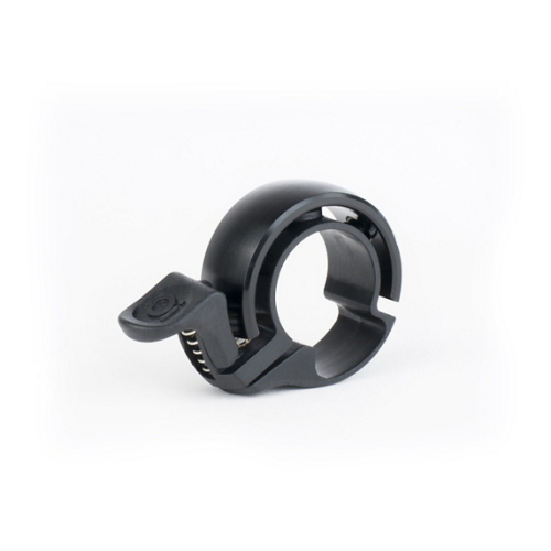 Ringklocka Knog Oi Classic - Svart, en svart rund ringklocka med minimalistisk design och integrerad tumspak, visas mot en vit bakgrund.