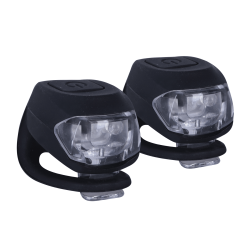 Lampset OXC Belysning Bright-Eye har två kompakta svarta LED-cykellampor med genomskinliga höljen och gummiband för enkel montering på cykeln, placerade sida vid sida mot en vit bakgrund.