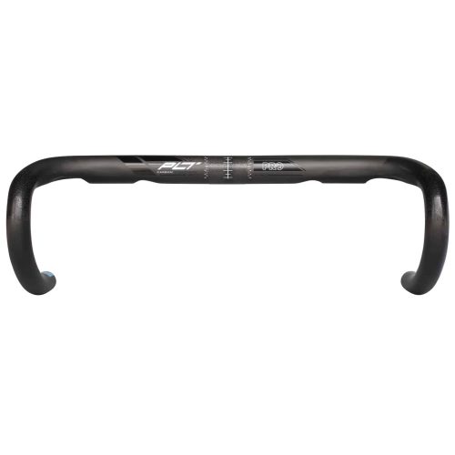 Svart PRO PLT Carbon Compact racerstyre i motljus, visar tydligt kolfiberstrukturen. Kontraster och djup fokus framhäver detaljerna i styret, som framstår minimalistiskt och stilrent.