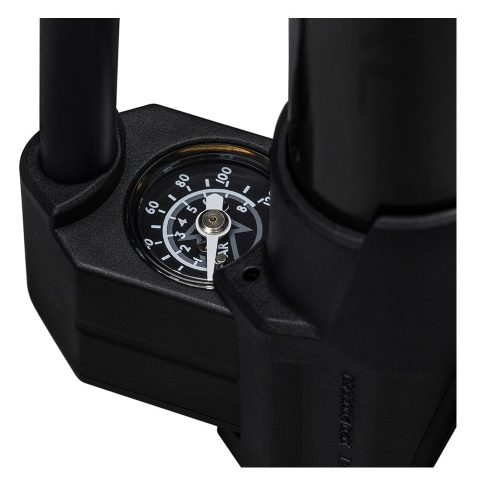 Närbild av Handpump Pro Performance XL Pop Out Minipumps svarta analoga mätare som visar psi och bar, med två cylindriska komponenter delvis synliga ovanför mätaren. Mätområde: upp till 11 bar.