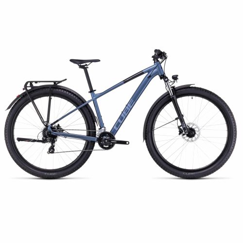 En blå Cube mountainbike med framgaffel med fjädring, rakt styre, skivbromsar, lasthållare bak, fram- och bakskärmar och knobbydäck, sedd från sidan mot en vit bakgrund.