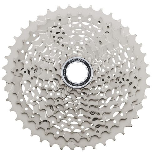 Detaljerad bild av en Shimano Deore CS-M4100 kassett, 10-växlad, i silverfärg. Stark belysning framhäver de intrikata detaljerna och den tekniska designen. Fokus på växelkombinationerna och Shimano-logotypen.