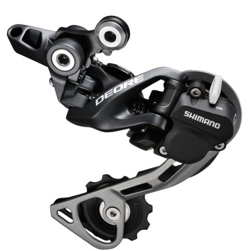 Detaljerad bild av en Shimano Deore RD-M615 Shadow+ bakväxel för 10-växlade system, med mörkgrå och silverfärgade element. Skarpt fokus framhäver 'DEORE'-loggan och 'SHIMANO'-märket.