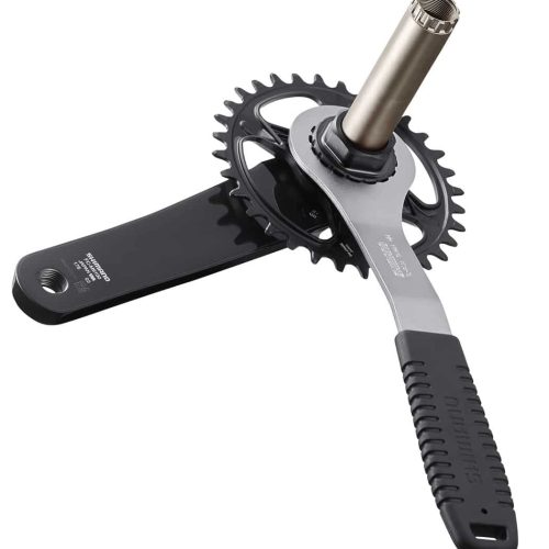 En detaljerad bild av verktyget Shimano TL-FC41 för direktmontering av främre kedjedrev. Verktyget används på en svart Shimano-vevarm och kedjekrans under starkt ljus.
