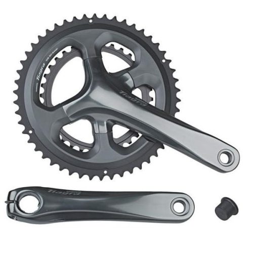 Detaljerad bild av ett Shimano FC-4700 Tiagra 10-växlat vevparti (52/36T) mot en vit bakgrund. Metallisk grå finish framhävs av ljuset som reflekteras på ytan.
