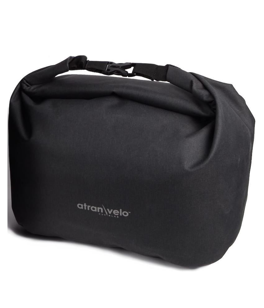 Travel-bag-for-Epic-korg-alu.jpg En svart, rektangulär Korgväska Atran Velo Travel 22 L mjuk väska för Epic korg, med rullstängning med plastspänne och "AtranVelo"-logotypen i vitt på framsidan.