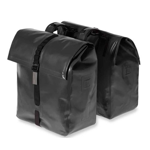 Två svarta, rektangulära Cykelväska Basil Urban Dry Double Bag packväskor (50L) med rullstängning och svarta spännband, stående sida vid sida mot en vit bakgrund.