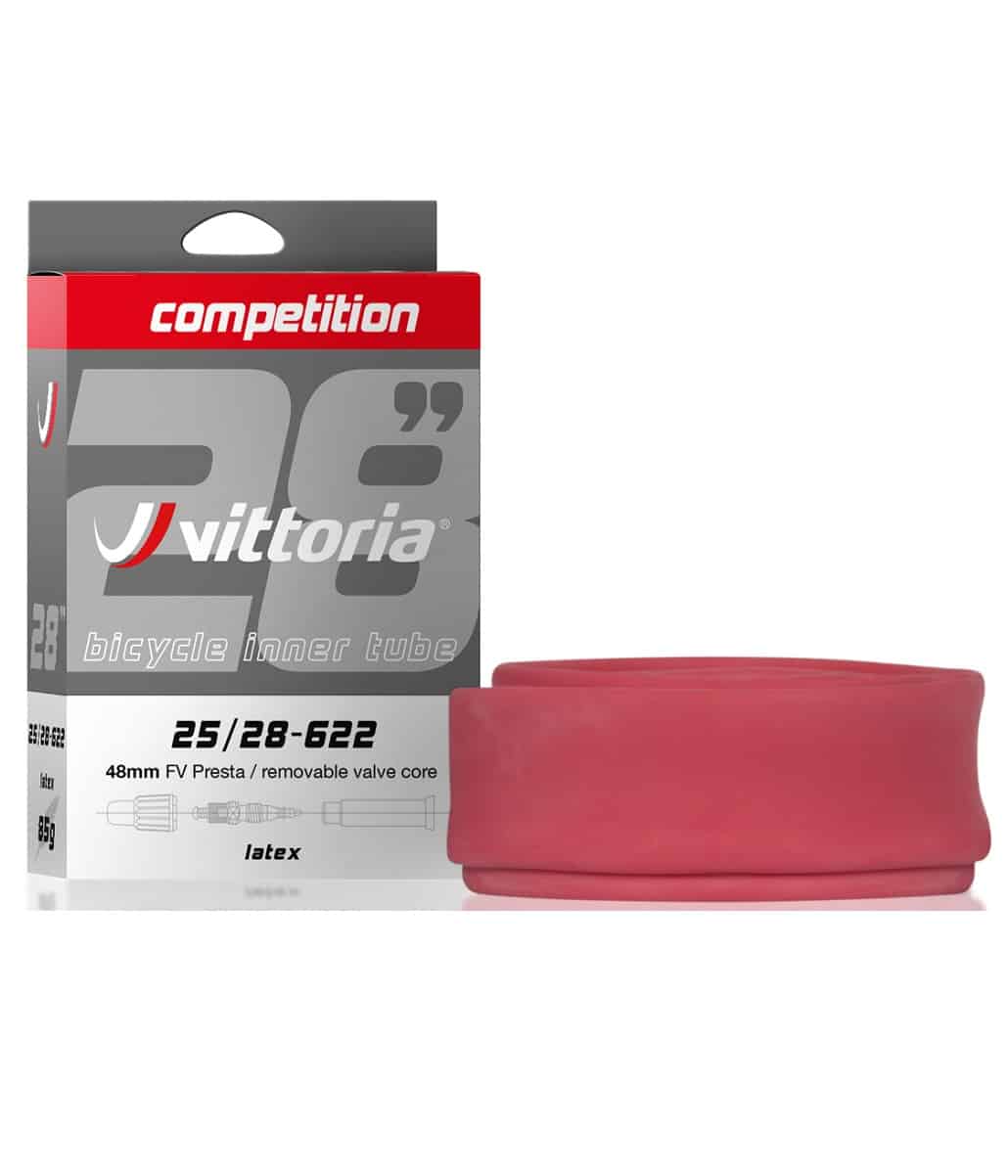 Vittoria-25-28-622-latex.jpg En detaljerad bild av ett Vittoria Competition cykeldäck i latex, förpackat i en låda bredvid den rullade produkten. Stark belysning framhäver produktdetaljer, vilket skapar en ren och informativ bild.