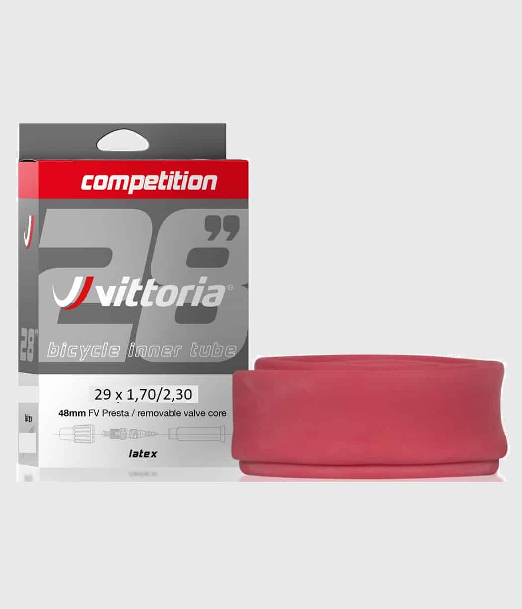Vittoria-Latexslang.jpg Produktfotot visar en förpackning Vittoria tävlingsslang för cyklar. Produkten ligger bredvid sin rödrosa latextub. Den gråa bakgrunden sätter fokus på de skarpa detaljerna.