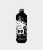 En flaska Vittoria Pit Stop tubelessvätska står mot en ljusgrå bakgrund. Flaskan är svart med vit text och ikoner som beskriver produktens egenskaper, inklusive dess användning för både racer- och mountainbikedäck.