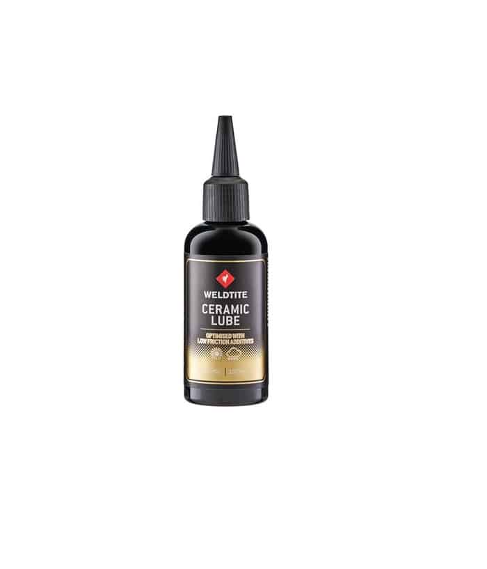 WELDTITE_Ceramic_Lube.jpg En svart flaska Weldtite Ceramic Lube, etiketten framhäver produkten i tydliga bokstäver och en guldaktig botten, stående mot en ren vit bakgrund i välbelyst atmosfär.