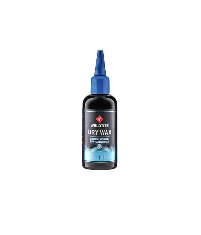 WELDTITE_Dry_Wax.jpg En flaska Weldtite Dry Wax, ett kedjevax för cyklar, står i ett neutralt ljus. Flaskan är svart med en blå pip och etikett med texten "DRY WAX".