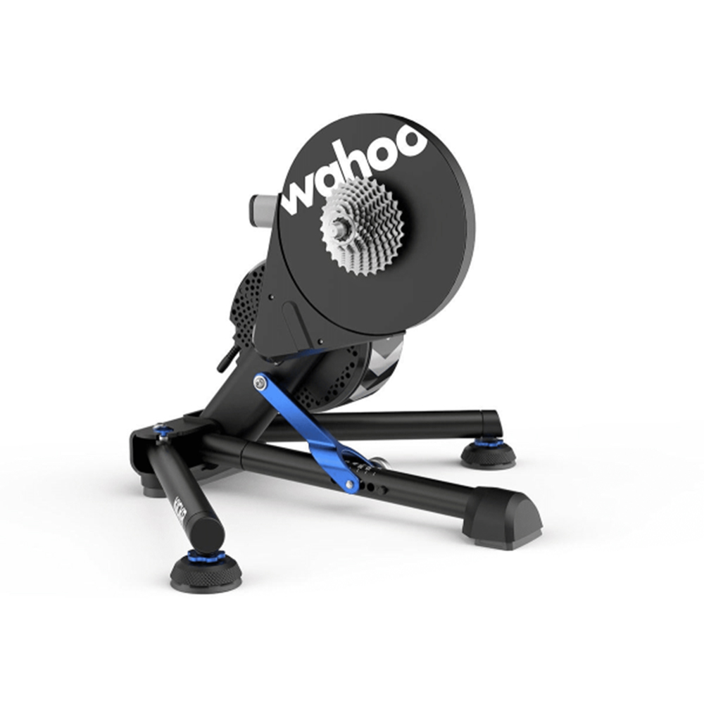 Wahoo Kickr v5 Trainer Wahoo Kickr V.5 trainer, avbildad i en studio med mjuk belysning. Fokus på den svarta ramen, det vita Wahoo-trycket och den silverfärgade kassetten.