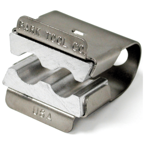 Silverfärgad axelhållare från Park Tool, AV-1, för skruvstäd. Metallisk glans under stark belysning framhäver detaljerna och graveringarna 'Park Tool Co.' och 'USA'.