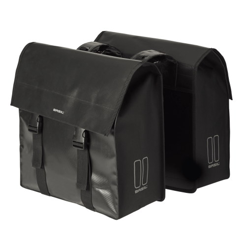 Två svarta, rektangulära Cykelväska Basil Urban Load dubbelväskor (53 L) av syntetmaterial med klaffstängning, spännen, subtilt varumärke och reflekterande sidoelement. Båda är placerade sida vid sida på en slät bakgrund.