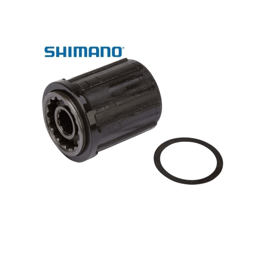 Närbild av en Shimano FH-RM35 frikropp tillsammans med en bricka, båda i svart. Produkten är avbildad mot en ren, vit bakgrund. Starkt ljus framhäver detaljerna på frikroppen och dess interna struktur.