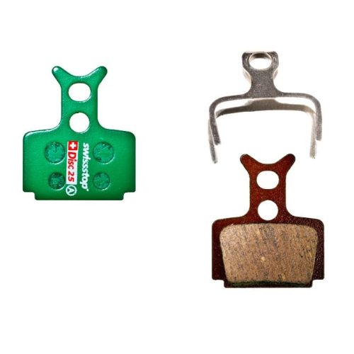 Två typer av skivbromsbelägg, en grön Swissstop Disc 25 och en brun med metallspänne, presenteras i detalj mot en ren, ljus bakgrund.