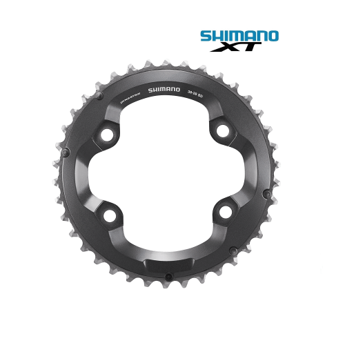 Närbild av ett Shimano XT FC-M8000 framdrev i grå nyans, belyst för att framhäva detaljerna i kugghjulen och texten 'SHIMANO' och 'DYNA-SYS II'.