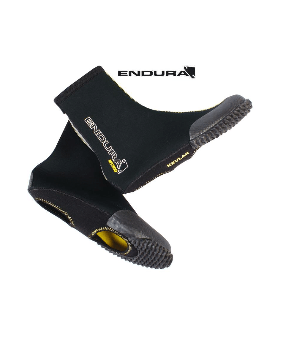 endura.mt500.11.png Ett par svarta Endura MT500 II vinter-skoskydd vattenskor med texturerade gummisulor, Kevlar-förstärkta tår och gult innerfoder. Enduras logotyp är synlig på båda skorna och ovanför dem mot en vit bakgrund.
