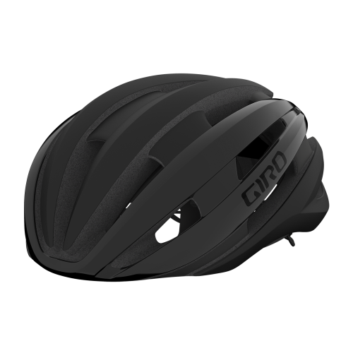En mattsvart Giro Synthe Mips II cykelhjälm framträder i studioljus, med fokus på dess aerodynamiska design och distinkta ventilationshål. Hjälmens texturer och 'GIRO'-logotypen framhävs tydligt.