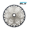 Detaljerad bild av en Shimano SLX CS-M7100 12-växlad kassett. Silverfärgade drev omges av en svart krans. Logotypen Shimano SLX syns tydligt i övre högra hörnet.