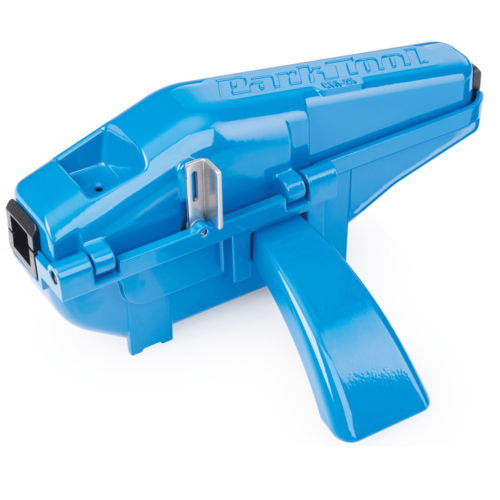Närbild av en blå Park Tool CM-25 kedjetvätt. Stark belysning framhäver produktens glansiga yta och detaljer som texten "Park Tool" och kedjemekanismen.