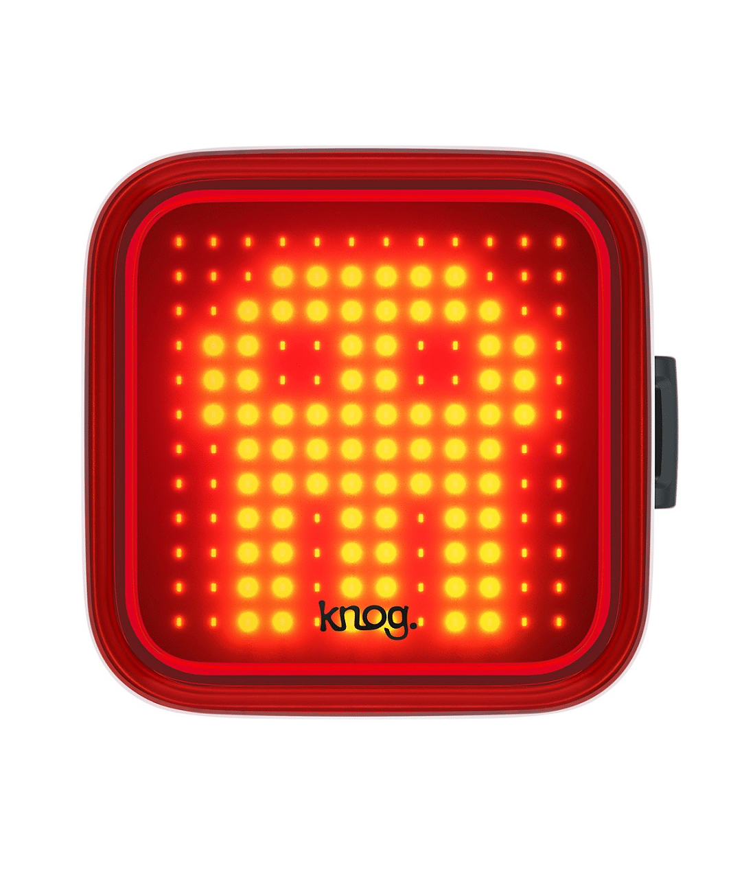 knog.blinder.skull_.png Knog Blinder Skull baklampa är en fyrkantig röd LED-cykellampa med en pixelerad gul spökdesign, rundade kanter, en sidoknapp och "knog." tryckt längst ner i mitten.