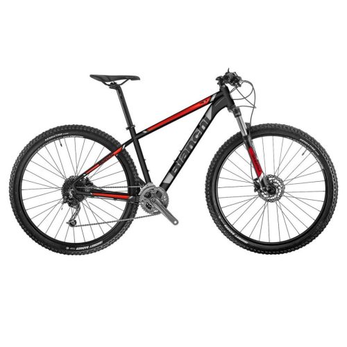 En svart och röd mountainbike med lättviktsram, framfjädrad gaffel, knobbydäck, skivbromsar och en drivlina med flera växlar, visad från sidan mot en vit bakgrund.