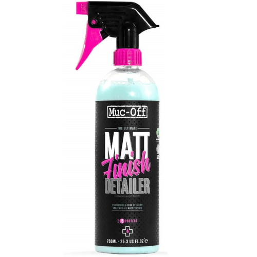 Muc-Off Matt Finish-rengöring i en svart sprayflaska med rosa detaljer. Flaskan är fylld med en ljusblå vätska. Stark belysning framhäver produktens detaljer och texturer.