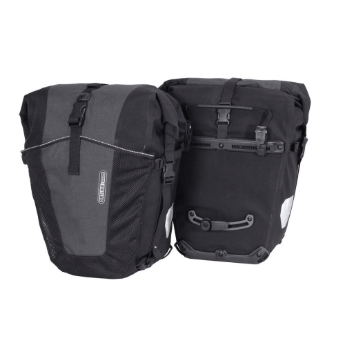 Par av Ortlieb Back-Roller XL Plus packväskor i svart och grått visas i en studiobild med jämnt ljus. Detaljer som spännen, meshfickor och reflektorer är väl synliga.